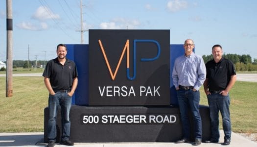 Versa pak employees standing in front of versa pak sign